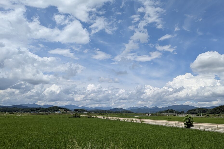 a landscape with clouds aligned in the blue sky